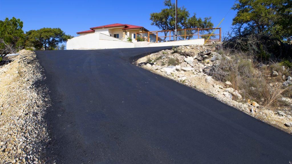 Asphalt drivway leading to house in the Texas Hill Counrty