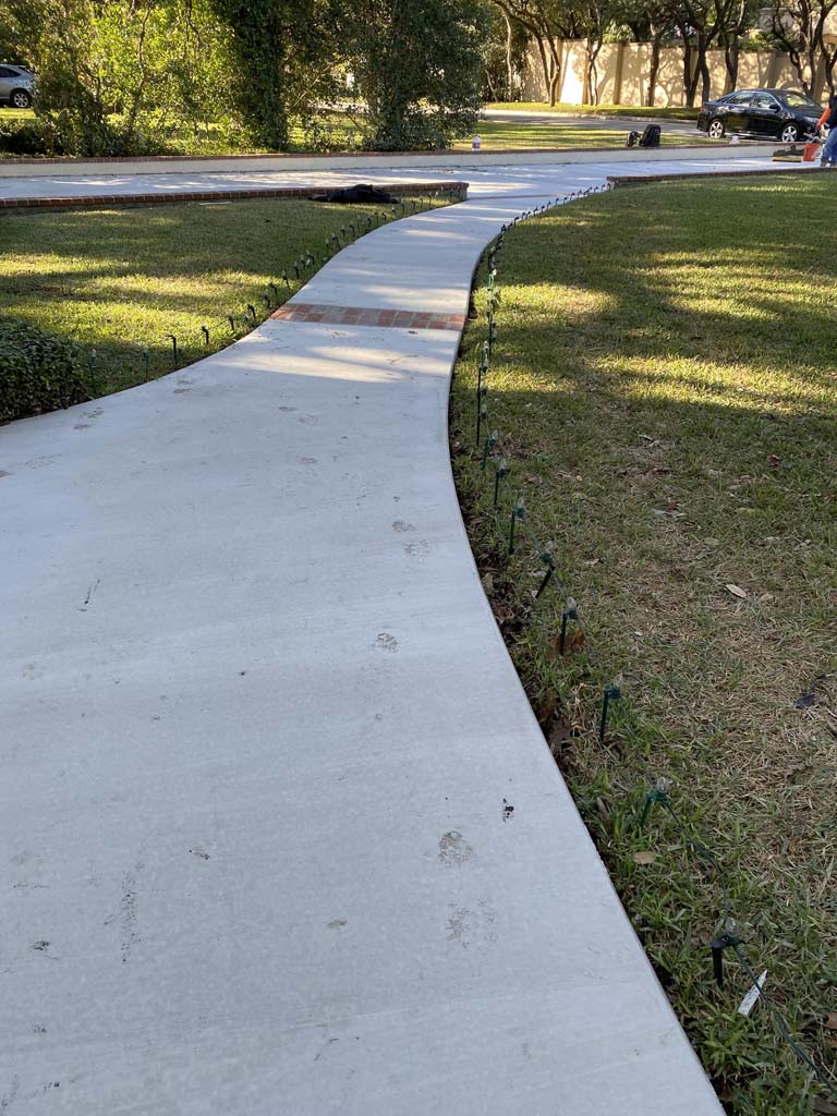Image of residential concrete sidewalk connecting to concrete driveway