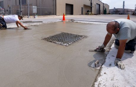 Image of concrete crew spreading and finishing concrete around storm drain